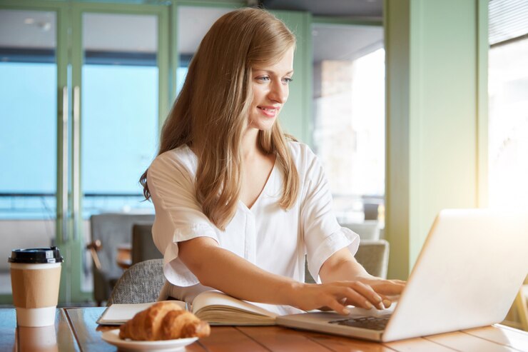 portrait-young-relaxed-woman-typing-laptop-sittingat-cafe-table_1098-20084